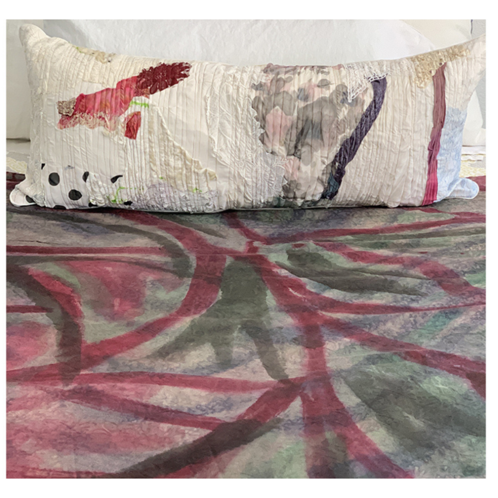 Decorative pillow with abstract design on a bed with matching bedding