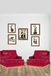 Two red armchairs in a room with framed artwork on the wall.