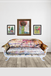 Decorative sofa with floral pattern in a room with framed artwork on the wall.