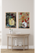 Two abstract paintings on a wall above a wooden console table with decorative items.