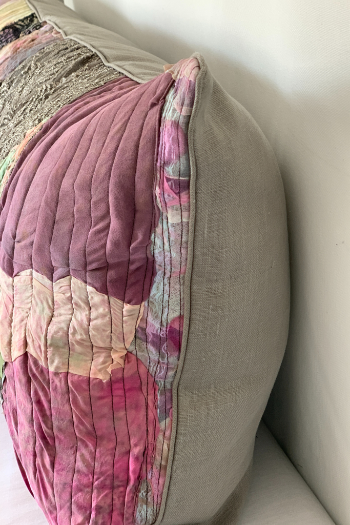 Floral-patterned quilt draped over a beige sofa