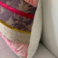 Decorative pillow with floral pattern and pink trim on a sofa