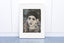 Handmade collage portrait of a woman with expressive eyes and a calm presence, created with textured hand-painted papers in deep blues and neutrals.