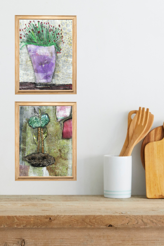 Two framed artworks on a wall above a wooden shelf with kitchen utensils.