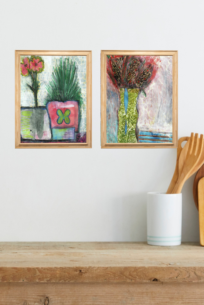 Two framed artworks on a wall above a wooden shelf with kitchen utensils.