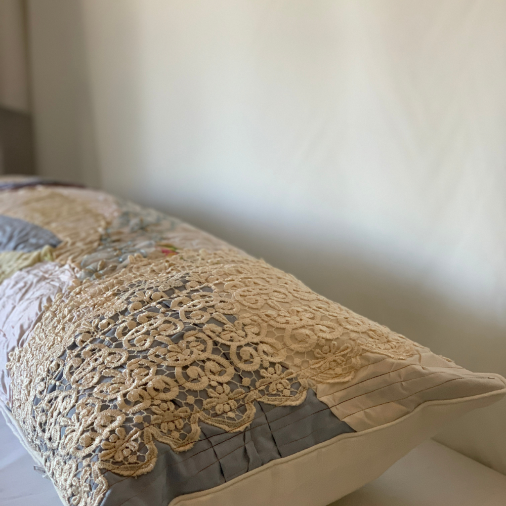 Decorative pillow with lace trim on a neutral background