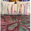 Colorful striped pillow on a bed with abstract patterned bedding
