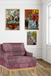 Purple armchair in a room with colorful abstract paintings on the wall.