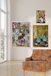 Three framed artworks on a wall above a patterned armchair.