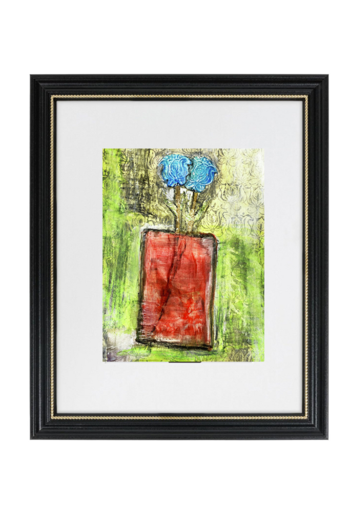Framed artwork of a vase with blue flowers and red fabric against a green background.