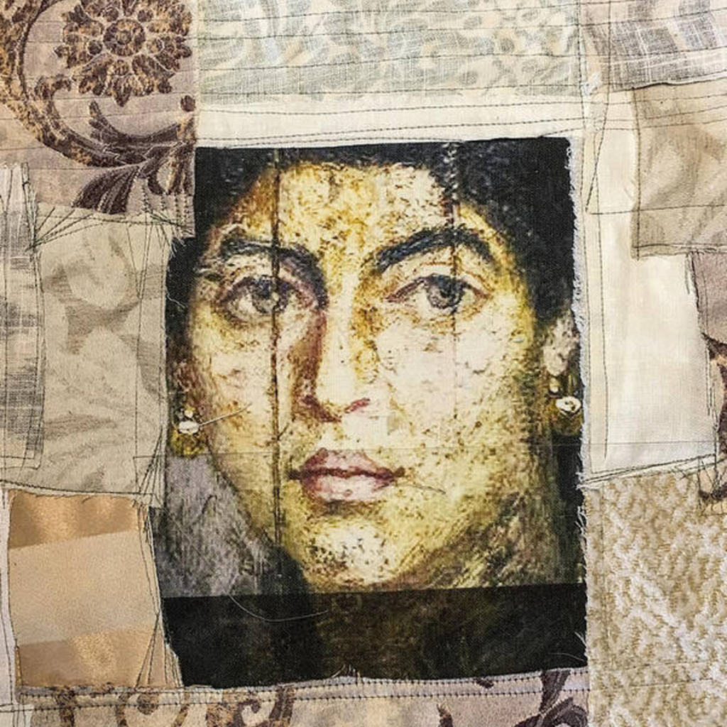 Textile art portrait of a woman’s face printed on fabric and stitched into a patchwork of vintage-inspired textiles in beige and gold tones.