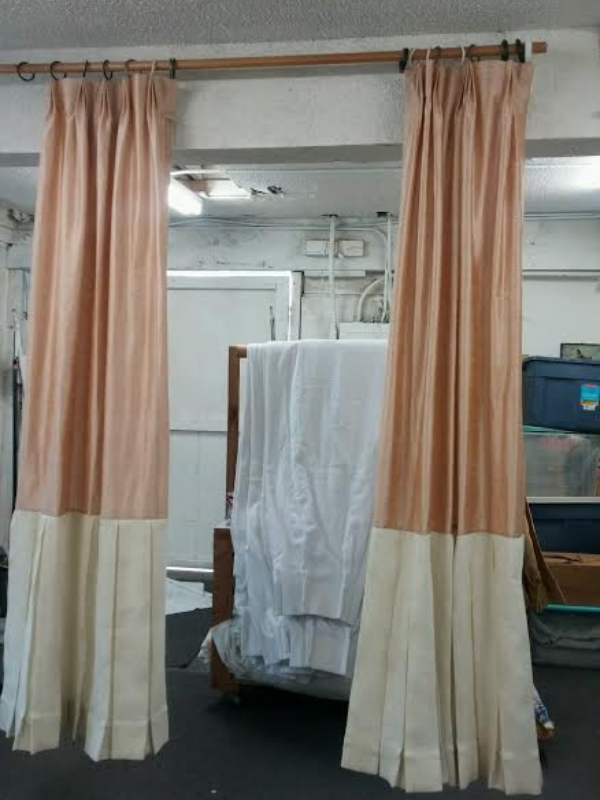Custom curtain panels hanging in a sunlit room, showing soft fabric texture and tailored fit designed for the window.