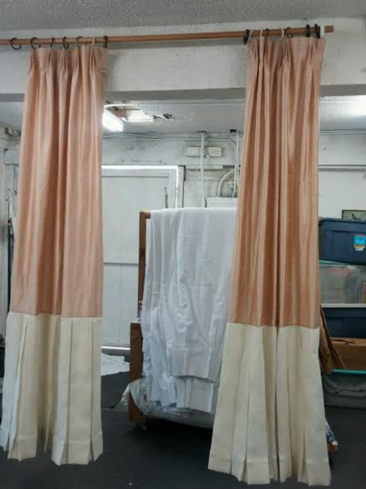 Custom curtain panels hanging in a sunlit room, showing soft fabric texture and tailored fit designed for the window.