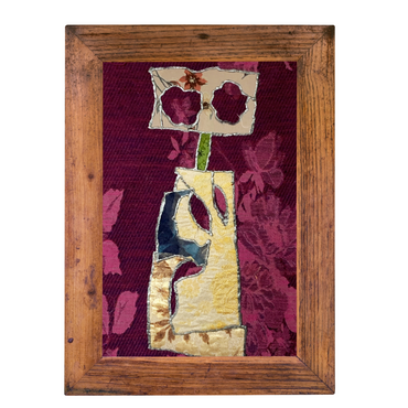 Framed textile art piece with a key design on a red floral background