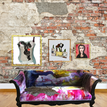 Colorful sofa in front of a brick wall with framed artworks.