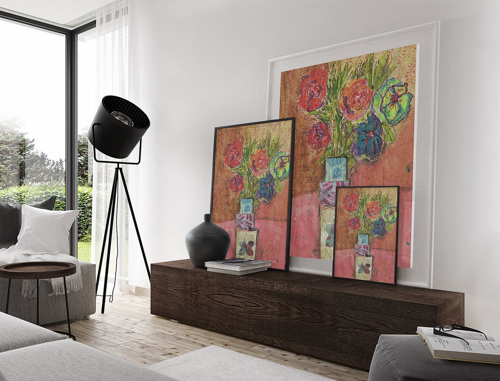 Mixed media collage titled Blood Moon by Sara Palacios. This vibrant piece features a colorful bouquet of flowers in red, orange, and green, placed in a geometric vase with bold patterns, set against a textured red and ochre background.