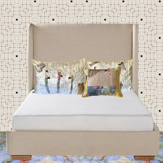 Beige bed with decorative pillows against a patterned wall