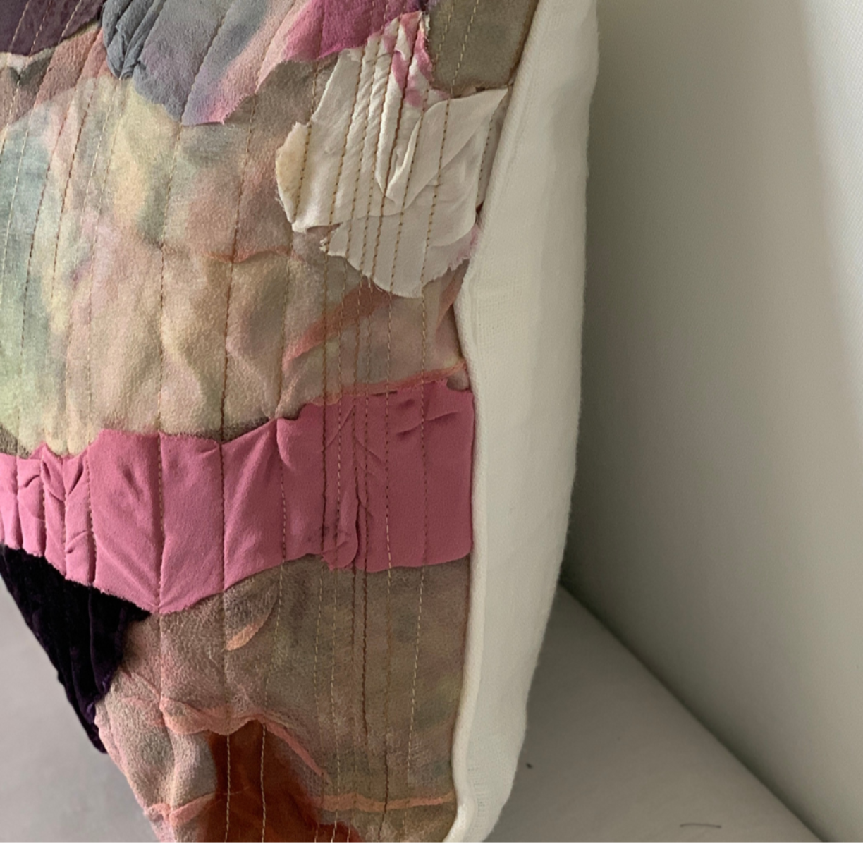 Patchwork quilt on a white surface with a neutral background