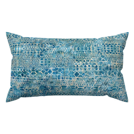 A rectangular lumbar throw pillow featuring an intricate, abstract geometric pattern in shades of blue and white, set against a plain white background.