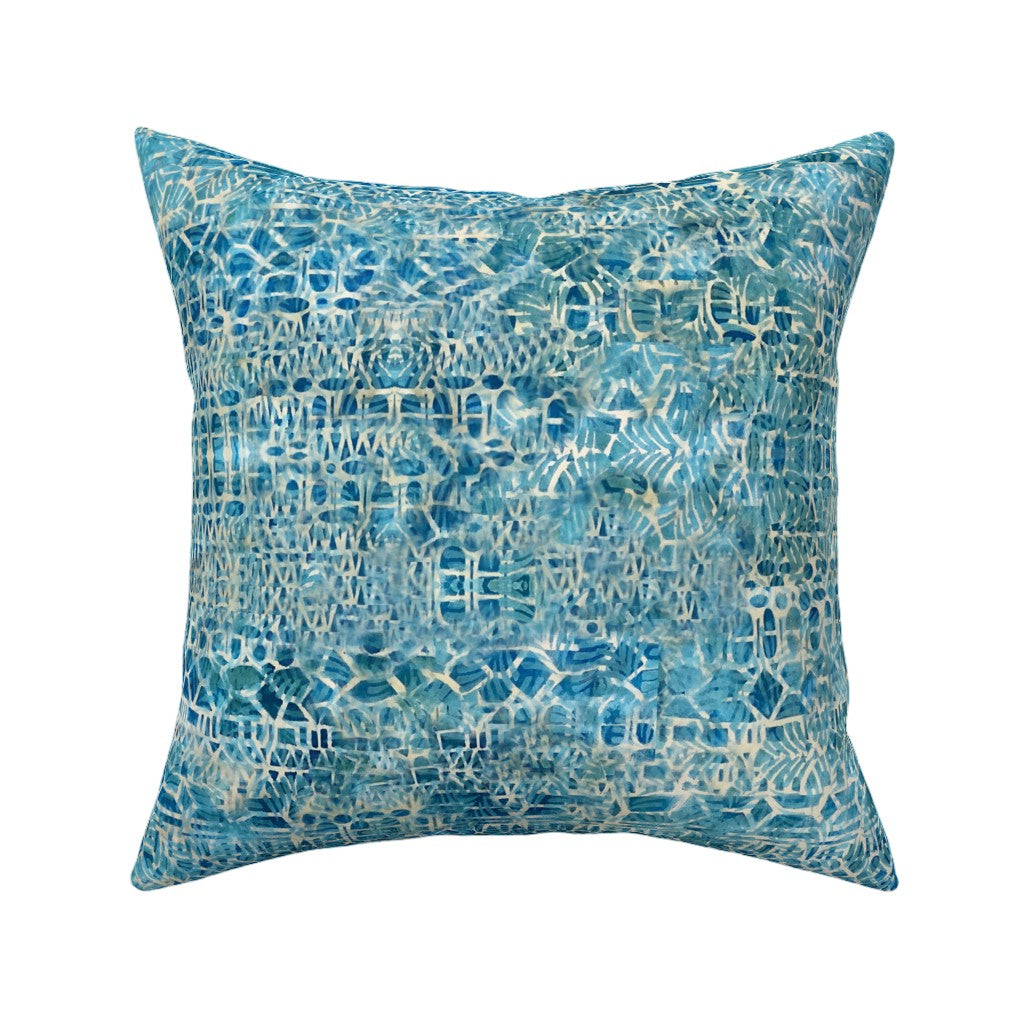 A square throw pillow featuring an abstract, watercolor-like pattern in shades of blue and white, set against a plain white background.