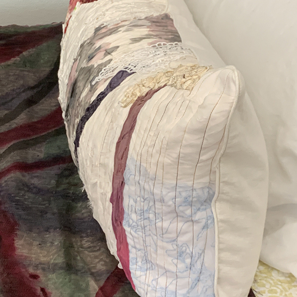 Close-up of a quilt with floral patterns draped over a chair.
