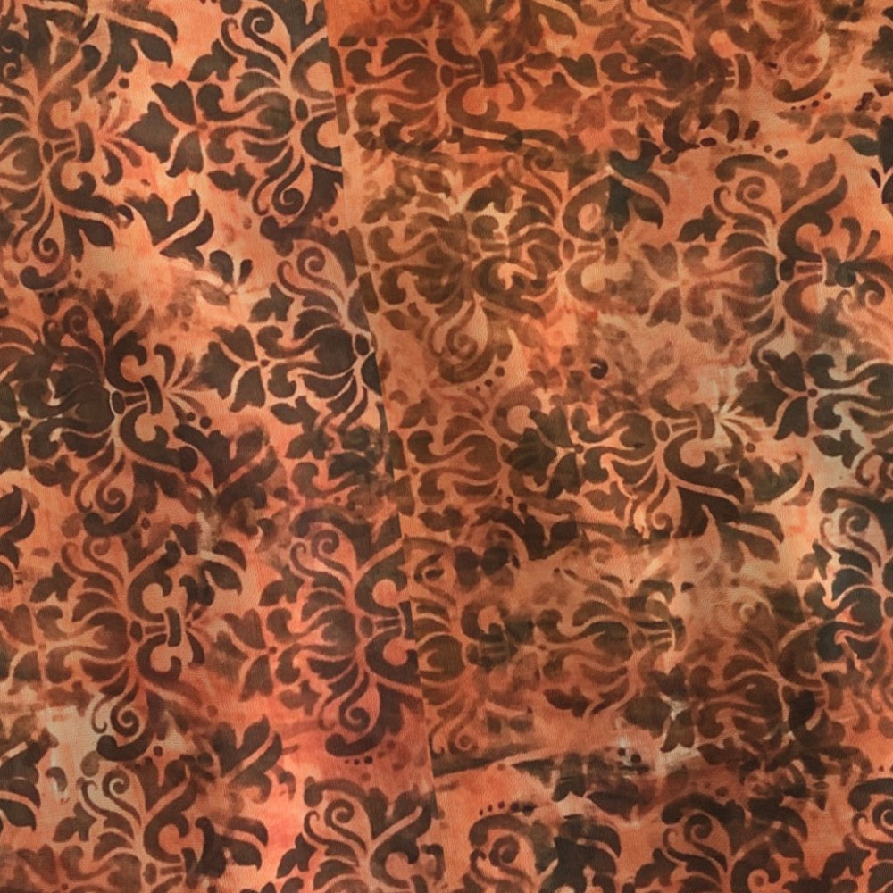 Decorative fabric with an intricate orange pattern on a brown background