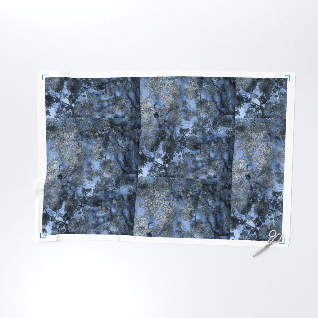 Blue and gray patterned fabric with scissors on a white background
