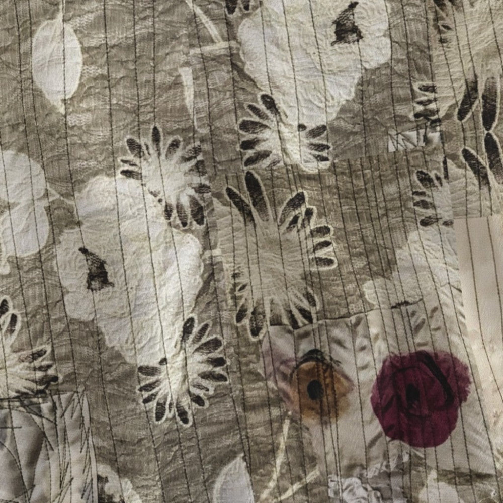Close-up of floral quilt with various flowers and leaves.