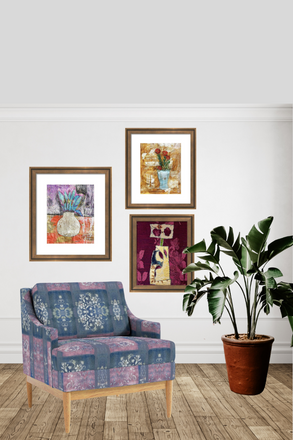 Decorative armchair with framed artwork and a plant in a room.