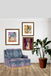 Decorative armchair with framed artwork and a plant in a room.