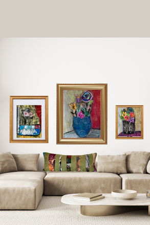 Three framed artworks on a wall above a beige sofa with a decorative pillow.