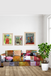 Living room with a colorful patchwork sofa, framed artwork on the wall, and a potted plant.