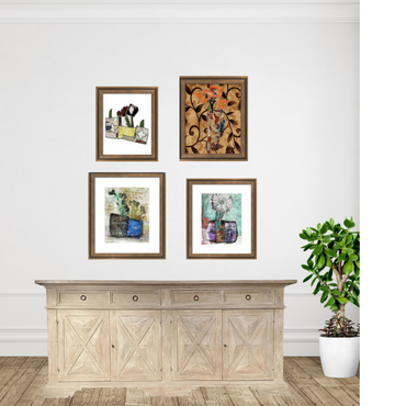 Framed artworks on a wall above a wooden sideboard with a plant in the corner.