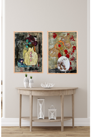 Two abstract paintings on a wall above a wooden console table with decorative items.