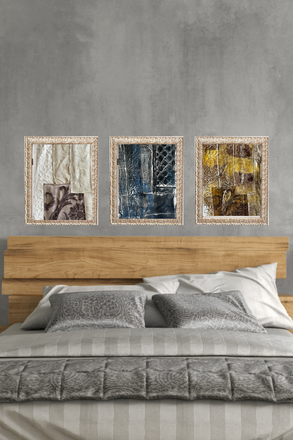 Three abstract art pieces above a bed with a wooden headboard.