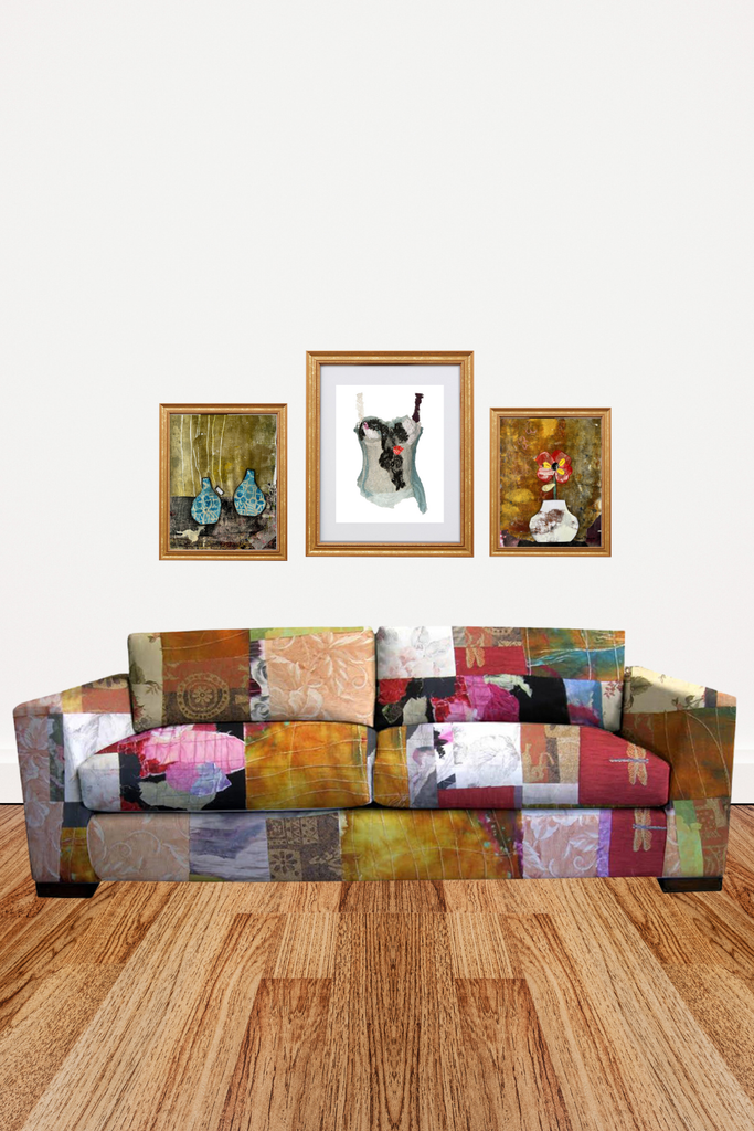 Colorful patchwork sofa with framed artworks on a white wall.