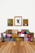 Colorful patchwork sofa with framed artworks on a white wall.