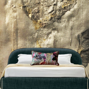 Bed with decorative pillows against a textured wall