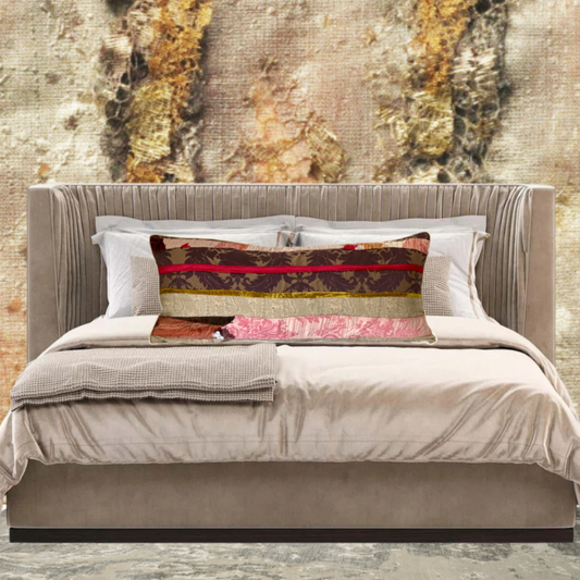 Neatly made bed with decorative pillows against a textured wall.