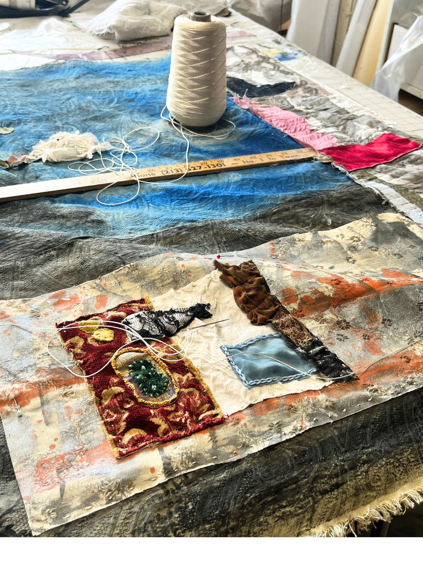 Textile art project with fabric pieces and thread on a table