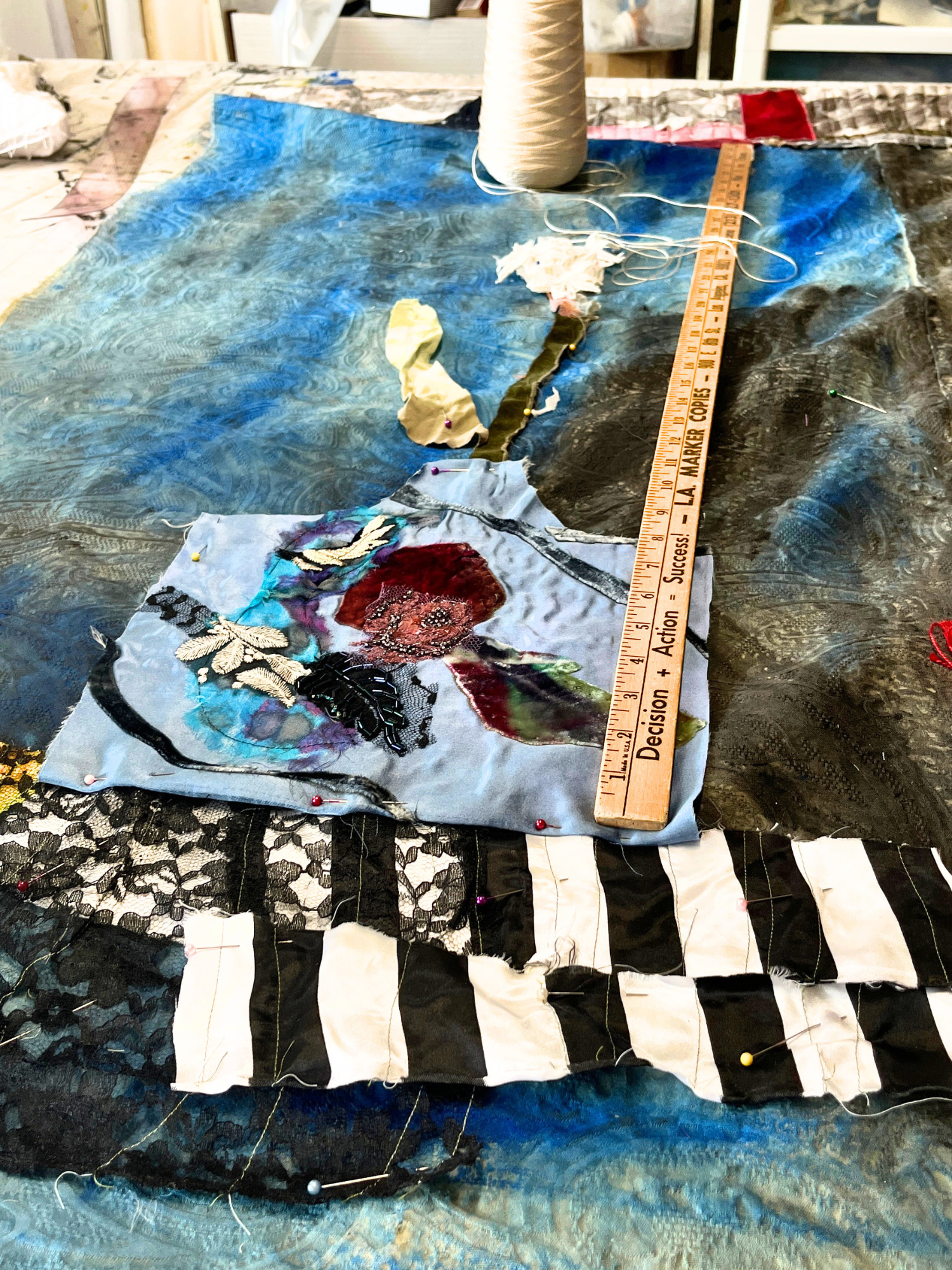 Textile art piece with a ruler for scale on a textured surface