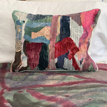 Multicolored patchwork pillow on a textured surface