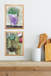 Two framed artworks on a wall above a wooden shelf with kitchen utensils.