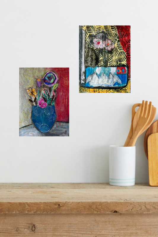 Two abstract paintings on a wall above a wooden shelf with kitchen utensils.