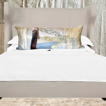 Decorative pillow on a bed with a textured wall in the background