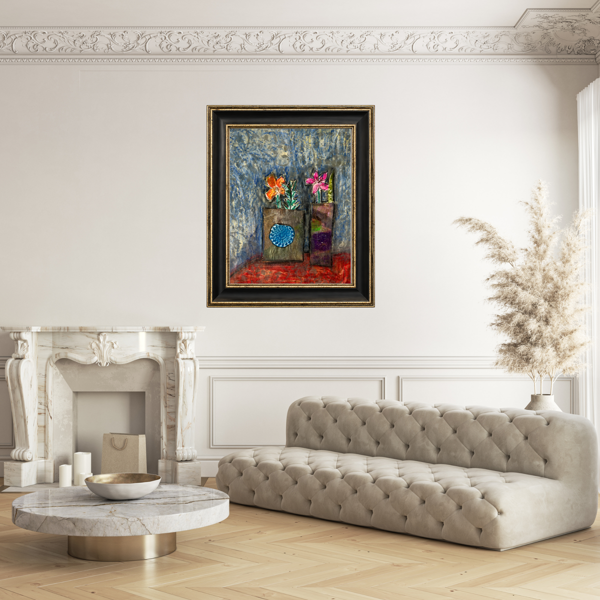 A framed abstract painting with vibrant floral and geometric elements hangs on a white wall above a tufted beige sofa in a styled living room with a marble fireplace and pampas grass.