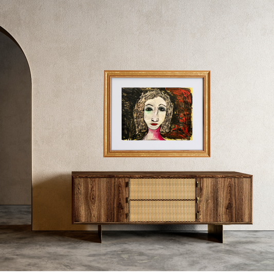 Framed artwork of a woman's face on a wall above a wooden cabinet.