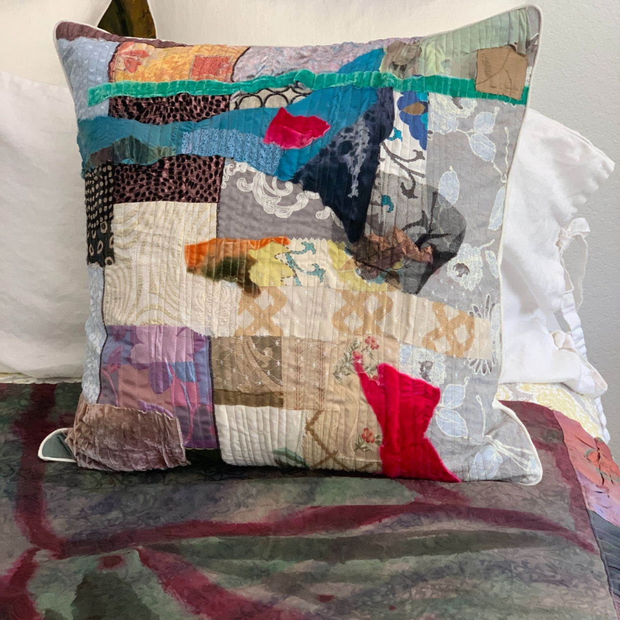 Multicolored patchwork pillow on a bed