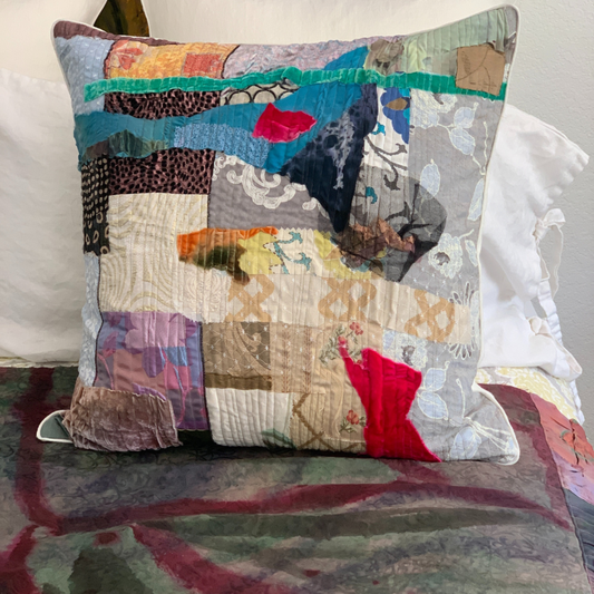 Multicolored patchwork pillow on a bed