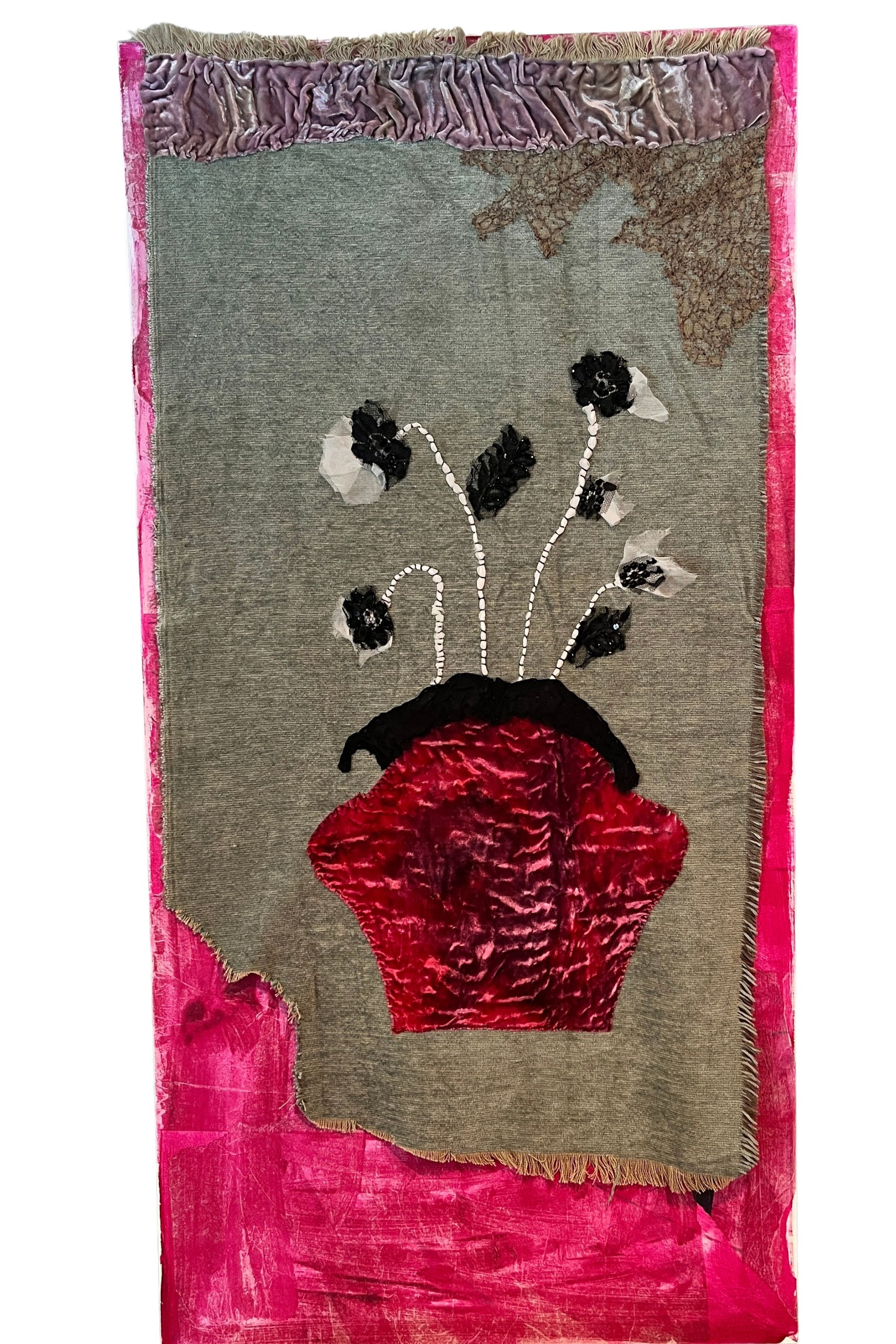 Textile art piece with floral design and red vase on a gray background